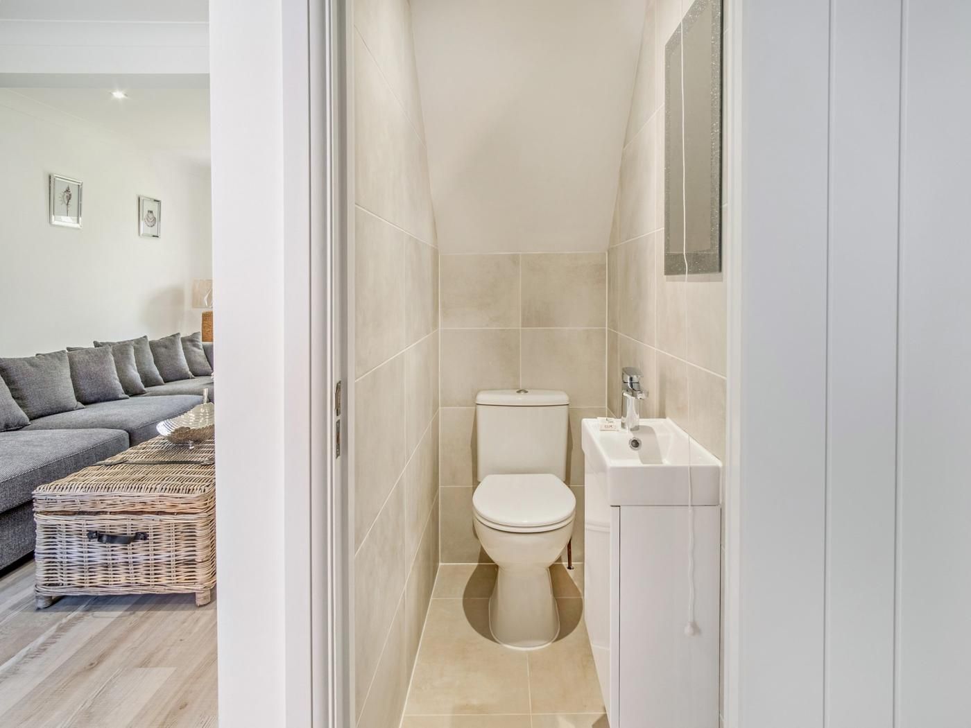 A bathroom with a toilet, sink, and tiled walls.