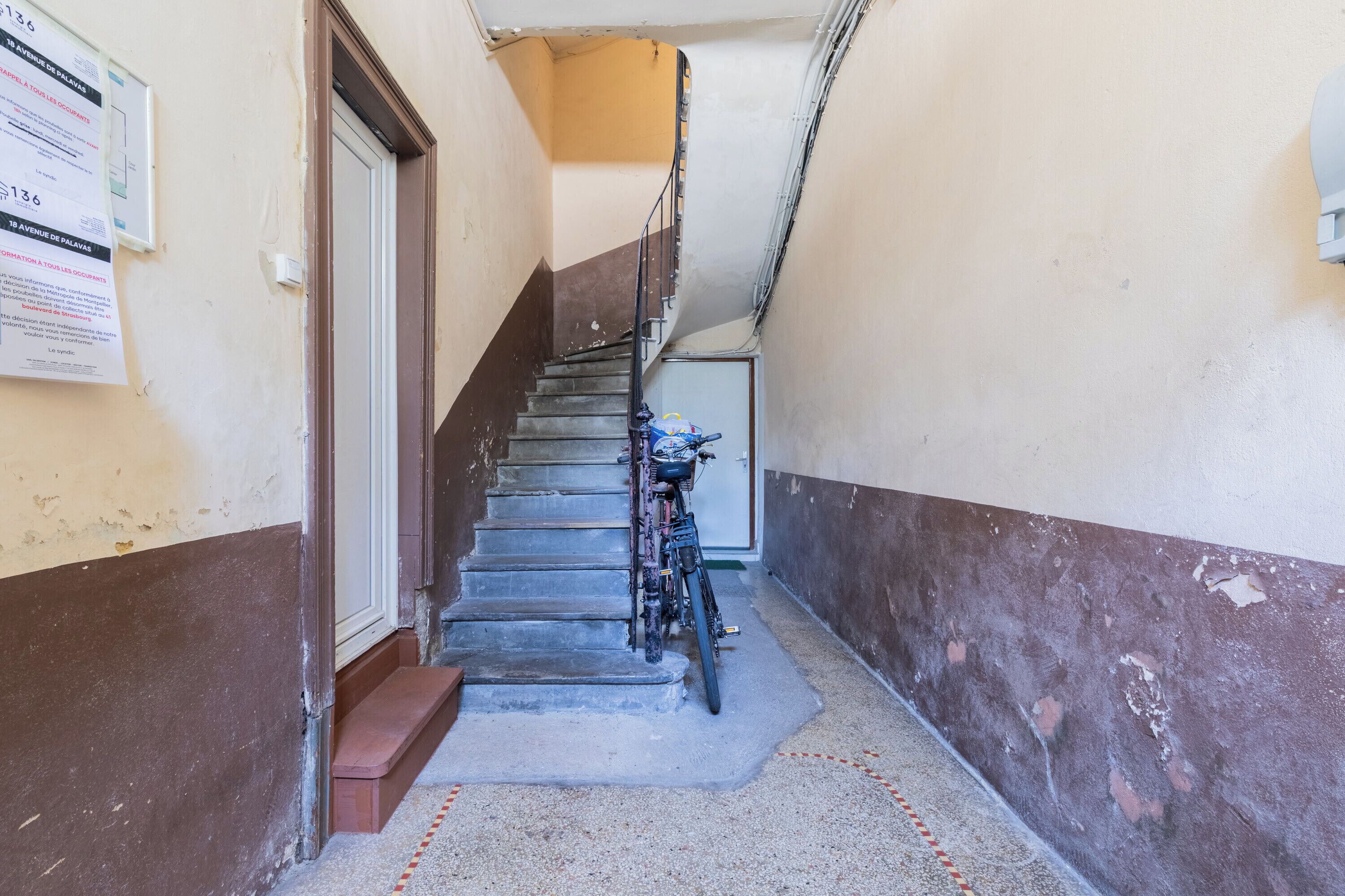 A narrow stairway with a bicycle parked at the bottom.