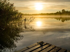 A wooden dock extending into calm water with a sunrise in the background. - 1 Bed in Forfar (oc-92332) (Burnside)