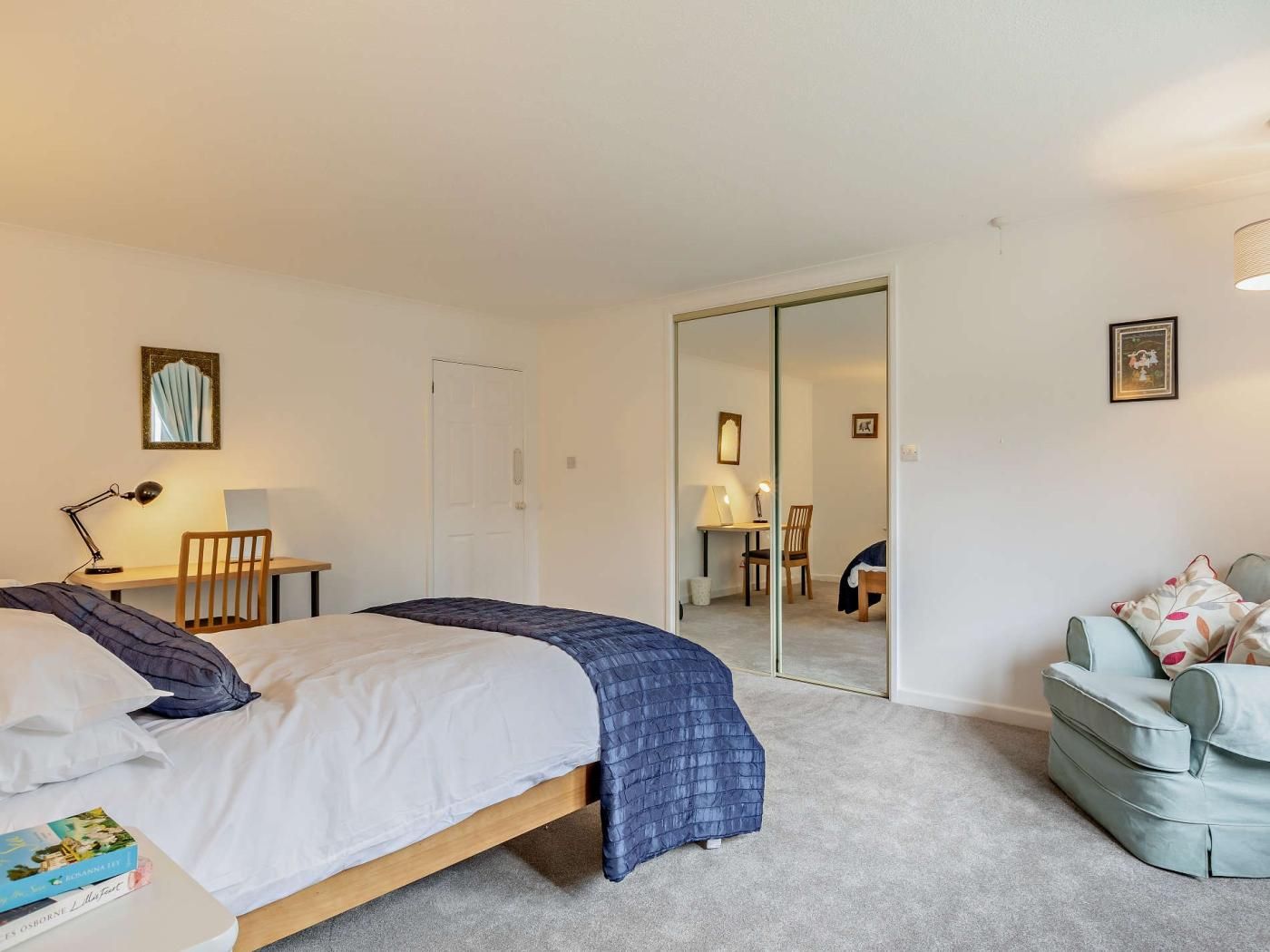 Une chambre à coucher avec un lit, une table de chevet, une lampe et une chaise.