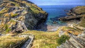 A coastal landscape with a stone staircase leading down to a beach. - 1 Bed in Launceston (oc-91964) (Tregadillett)