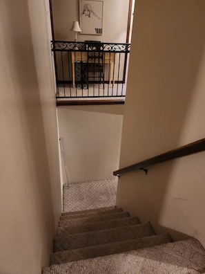 A staircase with a handrail, carpeted steps, and a railing with decorative elements.