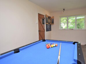 A pool table with balls and a cue stick, a window with a view of trees, and a door with a wooden panel. - 2 Bed in Dorchester (oc-92416) (West Dorset District)