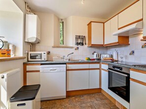 A compact kitchen with a dishwasher, microwave, stove, and oven. - 2 Bed in Dorchester (oc-92416) (West Dorset District)