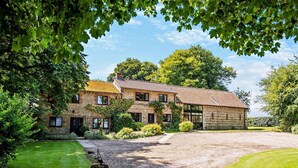 A two-story stone house with a gravel driveway and a well-maintained lawn. - 2 Bed in Dorchester (oc-92416) (West Dorset District)