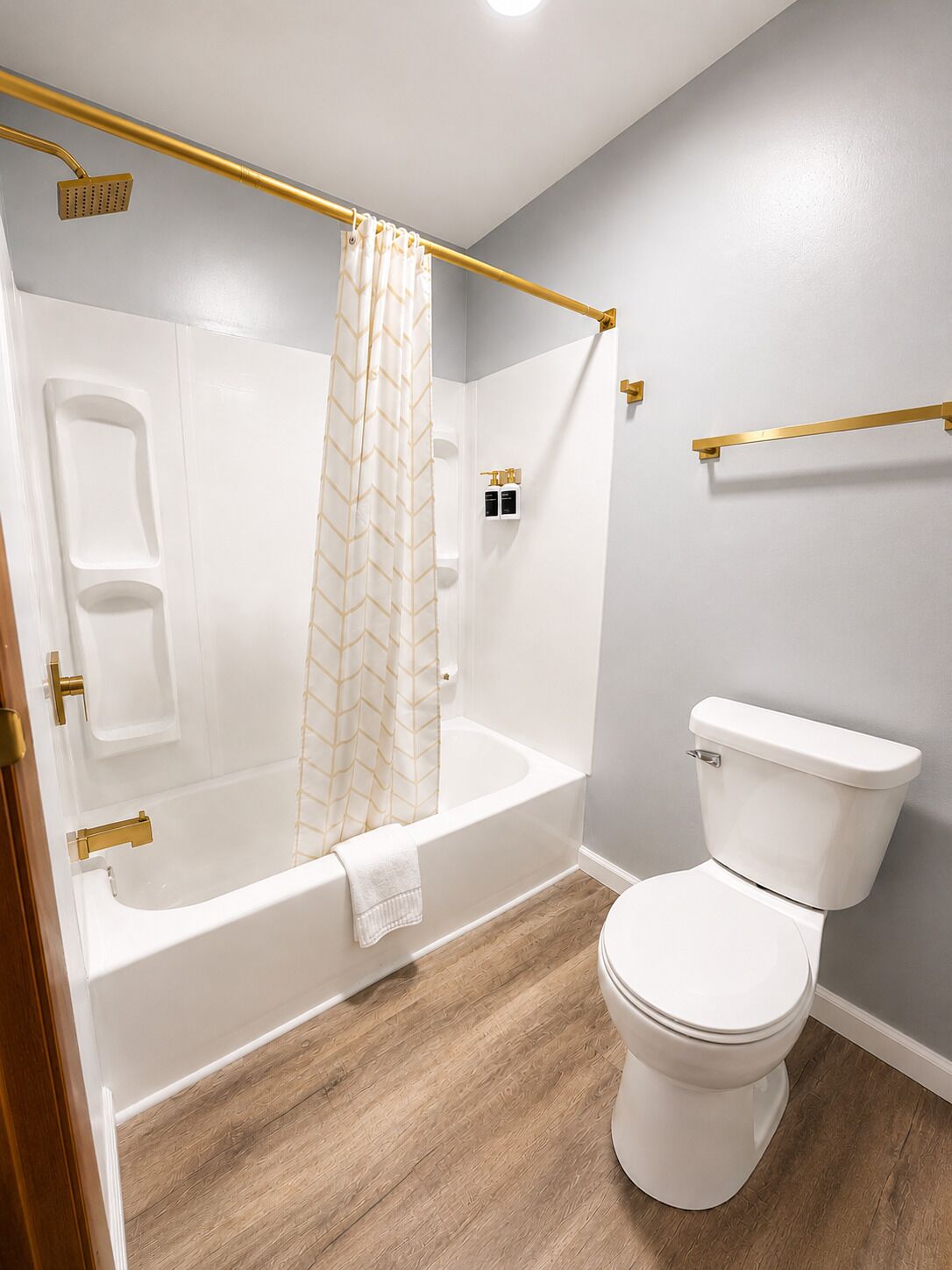 A bathroom with a bathtub, toilet, and shower curtain.