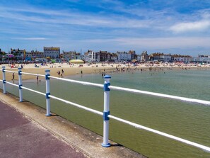A coastal promenade with a beach, promenade railing, and buildings in the background. - 3 Bed in Dorchester (oc-92415) (West Dorset District)