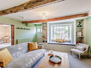 A cozy living room with a sofa, a coffee table, a window seat, and a bookshelf. - 3 Bed in Settle (oc-92466) (Settle)