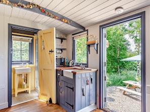 Eine moderne Küche mit großem Fenster, Holzschränken und einer Spüle.