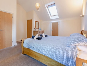 A bedroom with a skylight, a bed with patterned bedding, a dresser, and a mirror. - 2 Bed in Hayle (oc-92505) (Gwinear)