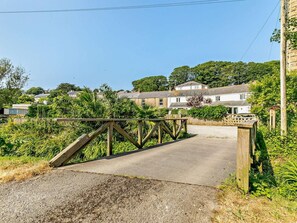 A rural road leading to a white house with a wooden bridge. - 2 Bed in Hayle (oc-92505) (Gwinear)