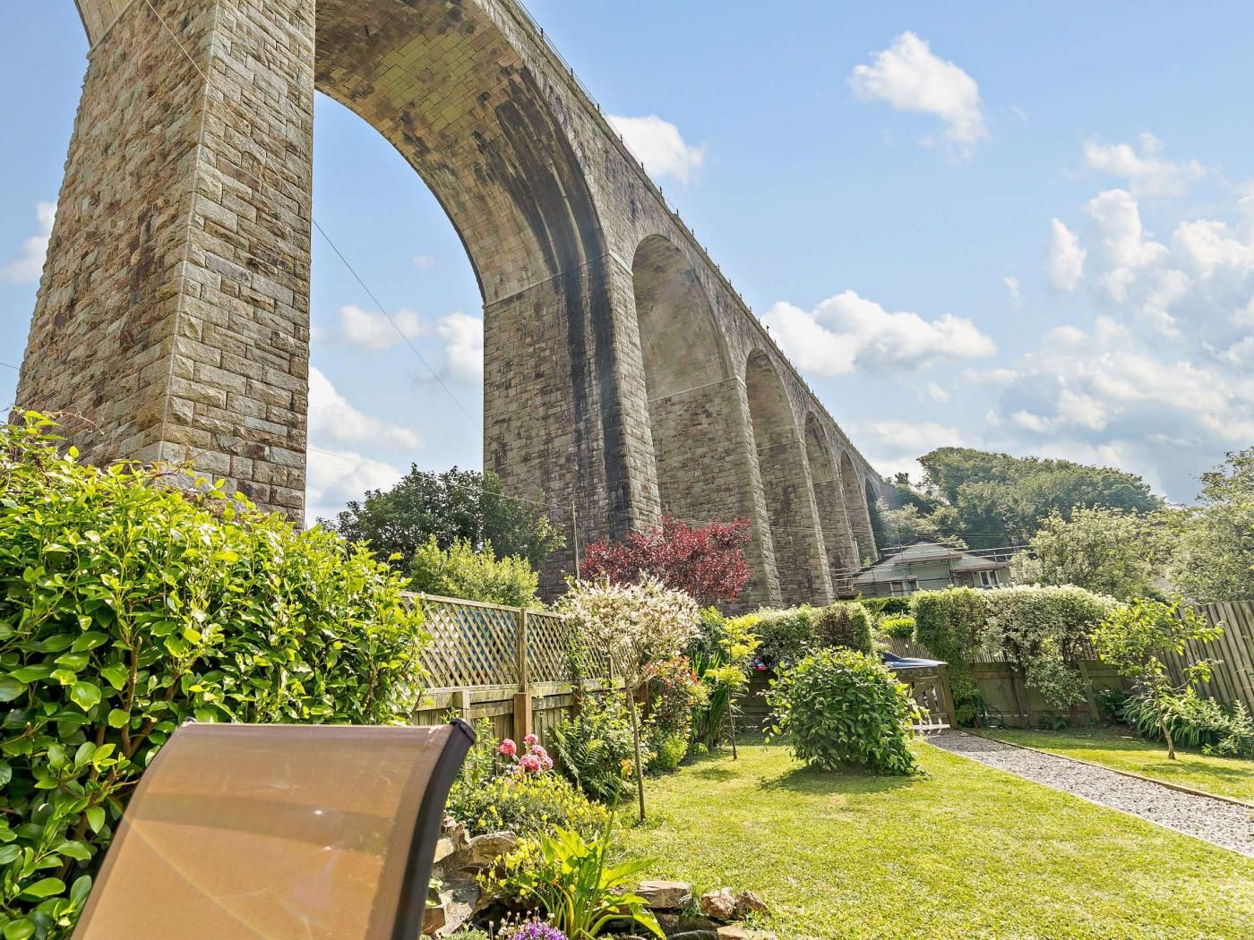 A stone bridge with a garden in the foreground.