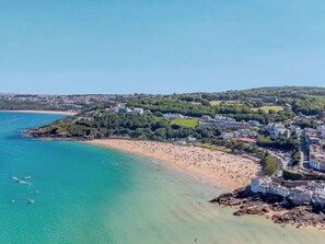 An aerial view of a coastal town with a beach, buildings, and greenery. - 2 Bed in Hayle (oc-92505) (Gwinear)