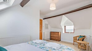 A bedroom with a bed, dresser, chair, and a window with a view. - 2 Bed in Matlock (oc-92639) (Holloway)