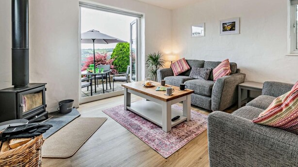 A cozy living room with a fireplace, a sofa, a coffee table, and a view of the outdoors. - 2 Bed in Matlock (oc-92639) (Holloway)