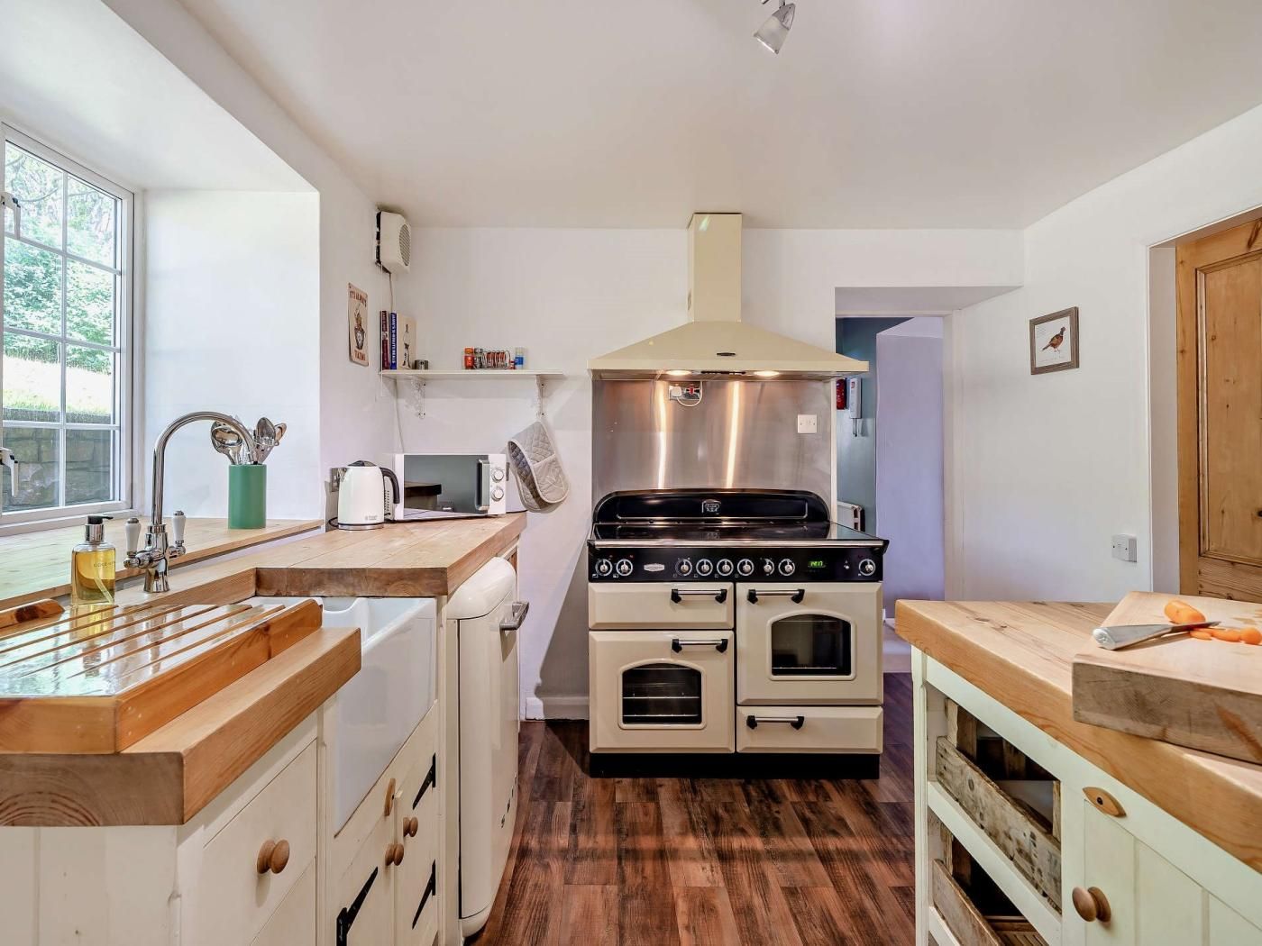 A compact kitchen with a central stove, a sink, and a window.