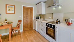 A compact kitchen with white cabinets, a microwave, a stove, and a sink. - 1 Bed in Harrogate (oc-92519) (Harrogate)
