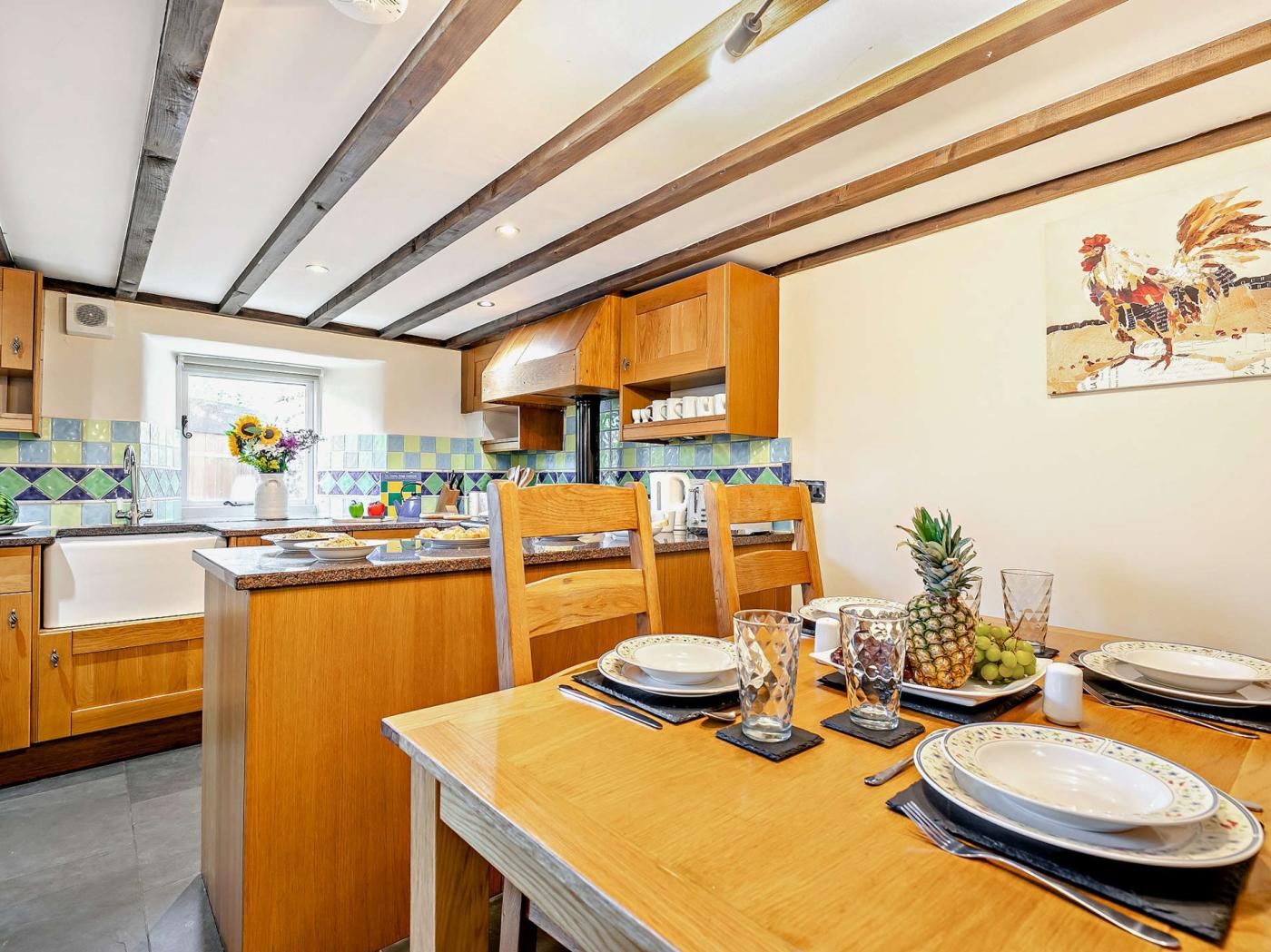 A kitchen with wooden cabinets, a tiled backsplash, and a dining area set for a meal.