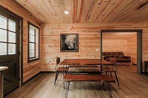 A wooden interior with a dining table, benches, a sofa, and a framed picture on the wall. - Dog Friendly 2bd/2bth family friendly hot tub (Sevierville)