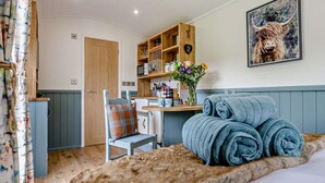 A cozy room with a bed, a chair, a wooden cabinet, and a painting on the wall. - 1 Bed in Penrith (oc-92641) (Deepdale)