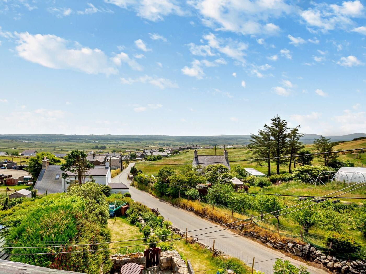 A rural village with houses, a road, and a clear sky.