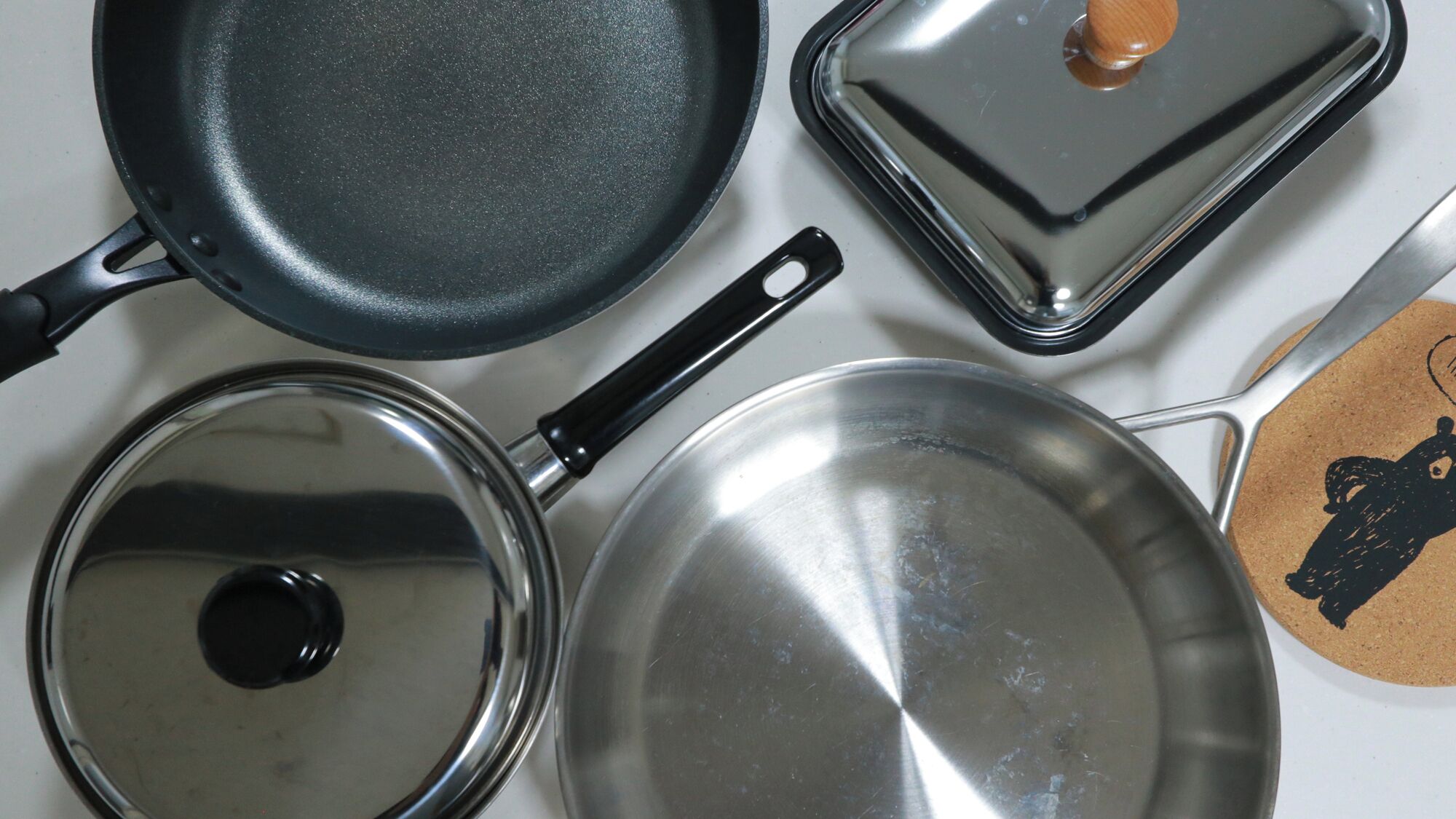 Een verzameling kookgerei, waaronder een koekenpan, een sauspannetje en een kookpot.
