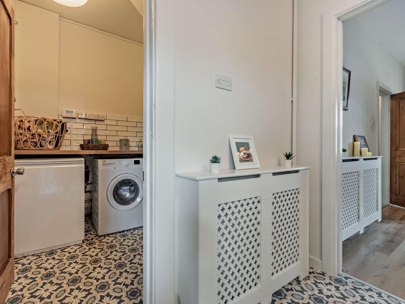 A laundry area with a washing machine, a dryer, and a small cabinet with a picture frame.