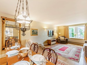 A dining area with a chandelier, a television, and a view of the outdoors through a window. - 2 Bed in Keswick (oc-92600) (Keswick)