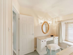A room with a white vanity, a mirror, a white bench, and a door. - 2 Bed in Keswick (oc-92600) (Keswick)