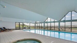 Ein Innenpool mit Blick auf die Landschaft, Liegestühle und ein Whirlpool.