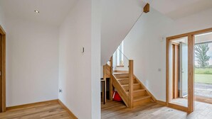 Ein geräumiges Zimmer mit einer Holztreppe, die zu einem Balkon führt.