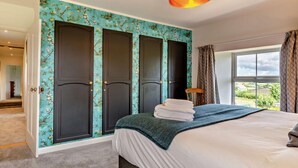 Ein Schlafzimmer mit Bett, Kleiderschrank und einem fenster mit Vorhängen.