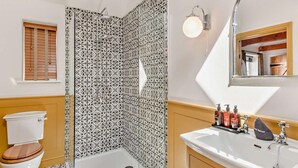 Ein Badezimmer mit Dusche, Toilette, Waschbecken und Spiegel.
