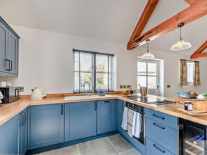 A modern kitchen with blue cabinets, a wooden countertop, a built-in oven, and a window with blinds. - 1 Bed in Lincoln (oc-92784) (Kirkby Green)