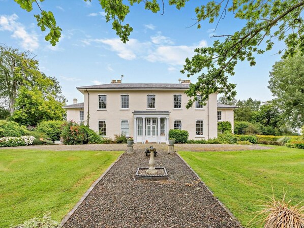 A large, two-story building with a symmetrical facade, a central entrance with a glass door, and a gravel pathway leading to it. - 4 Bed in Ludlow (oc-92835) (Cleedownton)