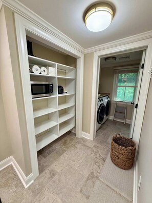 A laundry room with a washing machine, dryer, and shelves with household items. - Newly renovated 2bed/2 bath, pet friendly, easy walk to village! (Skaneateles)
