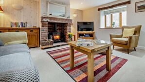 A cozy living room with a fireplace, a television, a sofa, and a coffee table. - 3 Bed in Wigton (oc-92826) (Torpenhow)