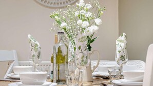A round dining table with white plates, glasses, and a pitcher, surrounded by a white wall and a decorative white object. - 3 Bed in Wigton (oc-92826) (Torpenhow)