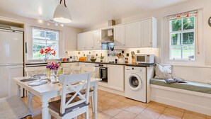 A compact kitchen with a dining area, a washing machine, and a window with a view of greenery. - 2 Bed in Blairgowrie (oc-92998) (Alyth)