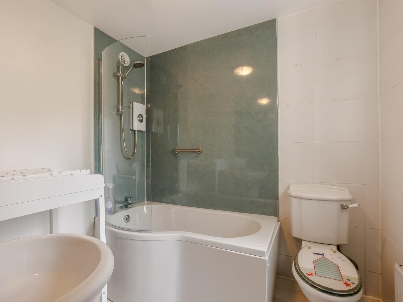 A bathroom with a bathtub, a glass-enclosed shower, and a toilet.