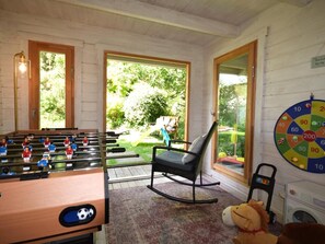 A room with a foosball table, a rocking chair, a toy lion, and a dartboard. - 4 Bed in Bideford (oc-93051) (Appledore)