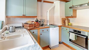 A kitchen with light blue cabinets, a wooden ceiling, a built-in oven, and a dishwasher. - 2 Bed in Driffield (oc-93141) (Langtoft)