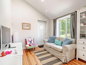 A modern living room with a sofa, a television, a small table, and a window with curtains. - 2 Bed in Driffield (oc-93140) (Langtoft)