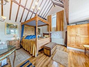 Ein Bett mit Baldachin, eine Kommode, ein Heizkörper und ein Holzschrank.