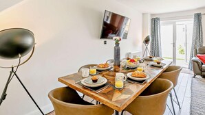 Un coin repas avec une table en bois, des chaises et des aliments pour le petit-déjeuner.