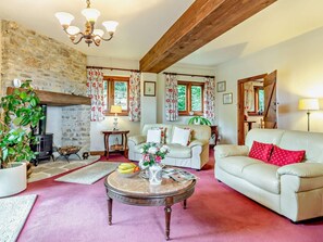 A cozy living room with a stone fireplace, a sofa, a coffee table, and a fireplace. - 3 Bed in Weymouth (oc-92902) (Osmington)