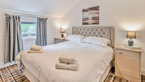 A bedroom with a bed, a bedside table, a lamp, a window with curtains, and a painting on the wall. - 2 Bed in Sheffield (oc-92978) (Upper Midhope)