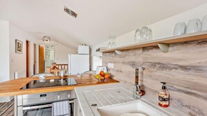 A modern kitchen with a built-in oven, a sink, and a wooden countertop. - 2 Bed in Sheffield (oc-92978) (Upper Midhope)
