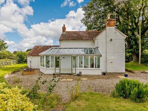 A white house with a conservatory, a brick chimney, and a gravel driveway. - 3 Bed in Pershore (oc-92975) (Eckington)