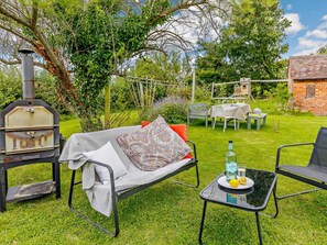 An outdoor seating area with a grill, a table with drinks, and a garden setting. - 3 Bed in Pershore (oc-92975) (Eckington)